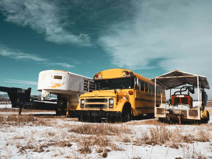 two school buses sit in the snow by one another