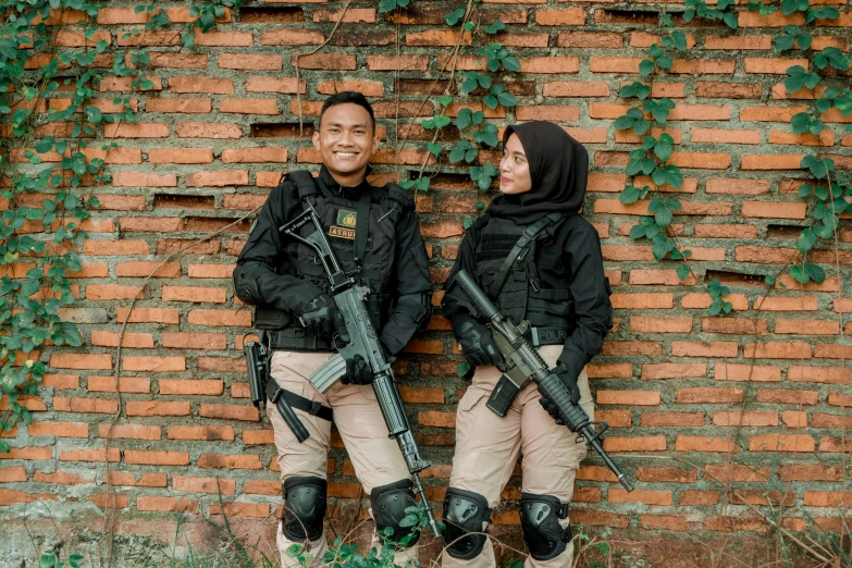 a couple of people standing next to each other holding rifles