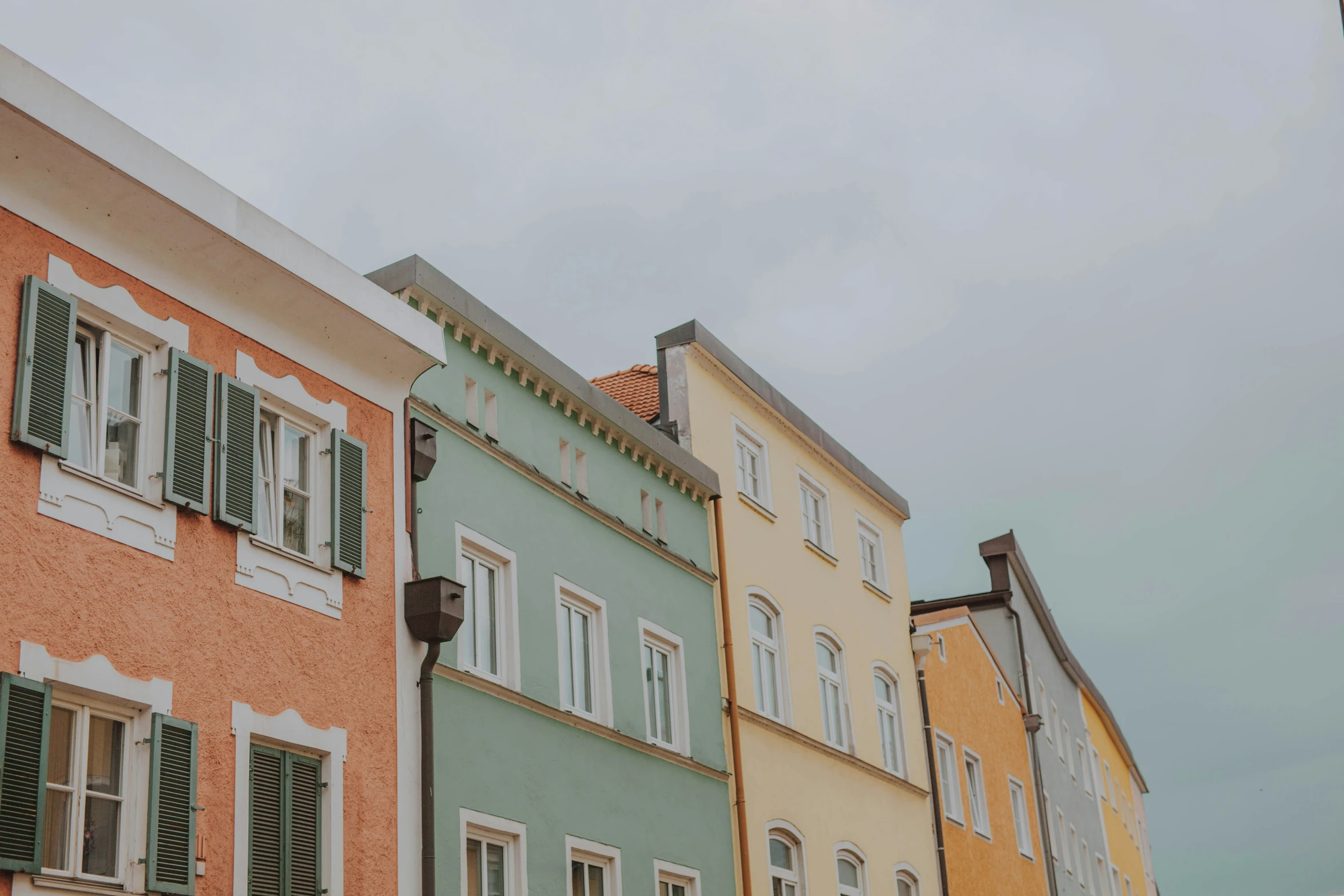 four colorful buildings are against a cloudy sky