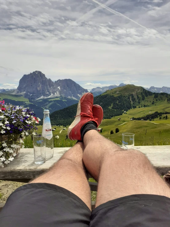 a pair of feet on a bench overlooking mountains