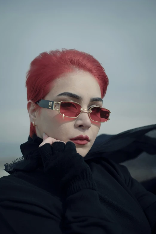 woman with red hair and sunglasses on a beach