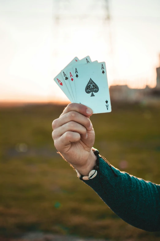 the person is holding up playing cards on the field