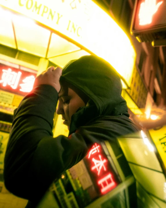 a man holding soing to his face next to neon signs