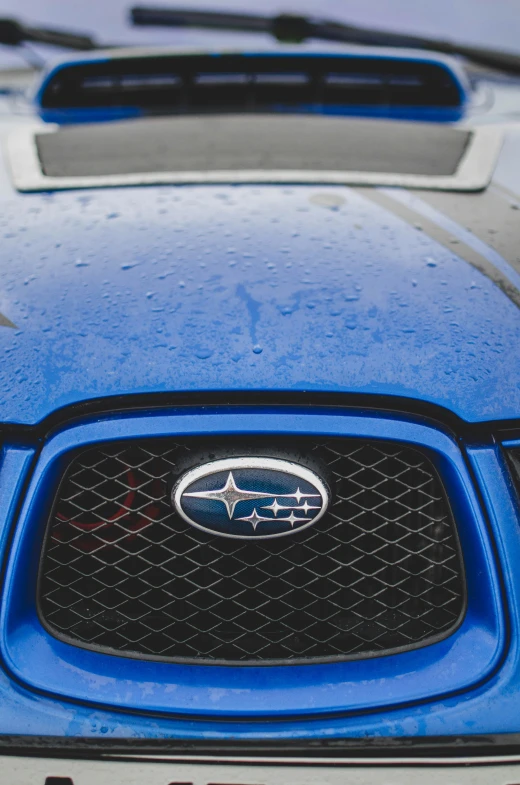 a blue car with the hood up and grille vents open