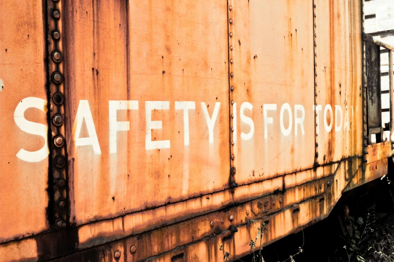 a rusted and rusty rail car with white words saying safety is for road