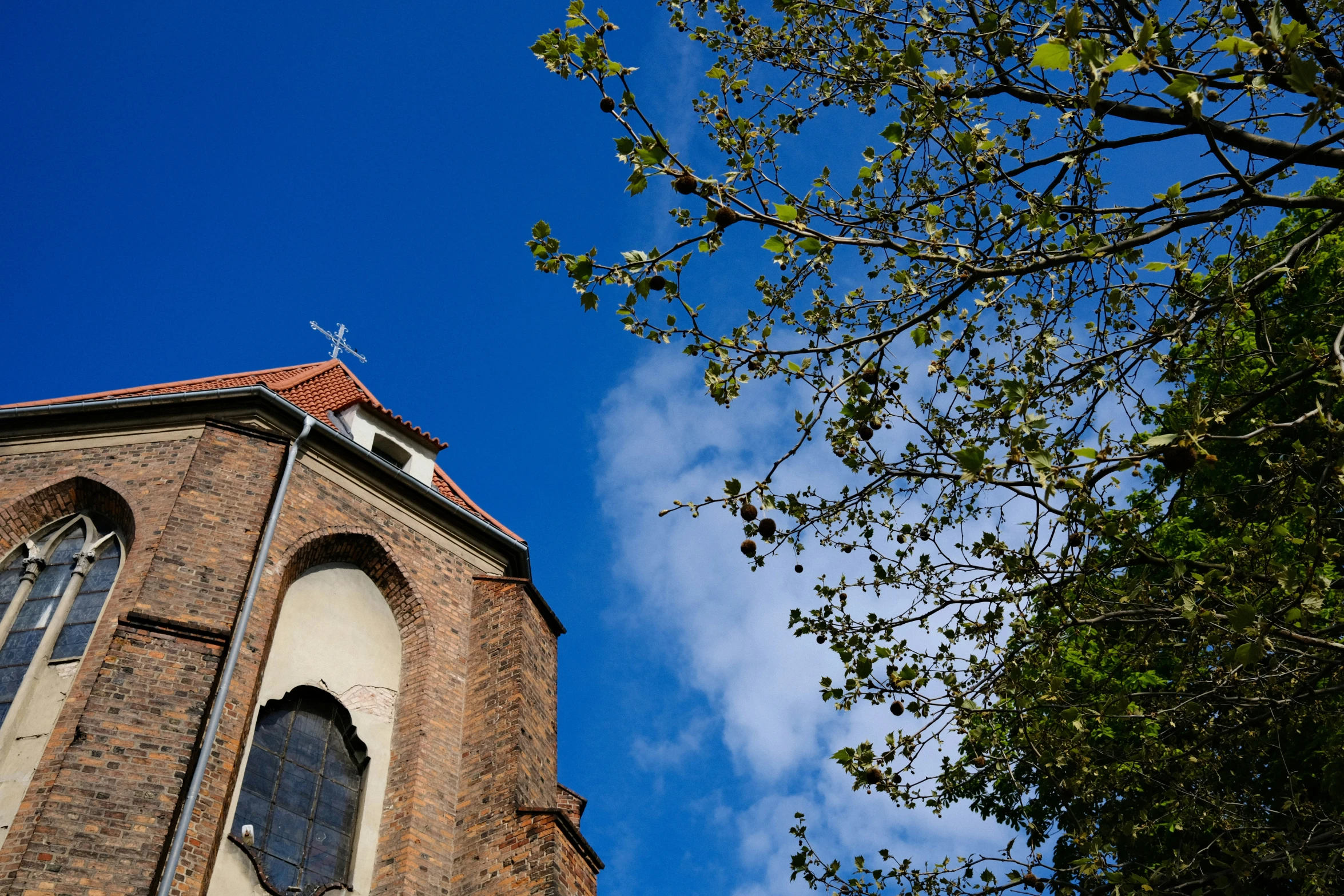 a tall brick church has a cross on it