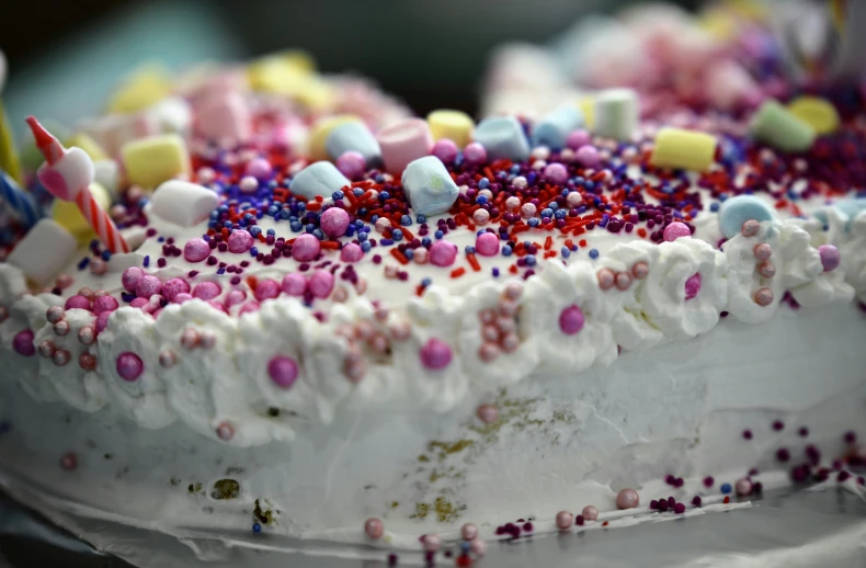 a white cake with a white icing topped with sprinkles and candles