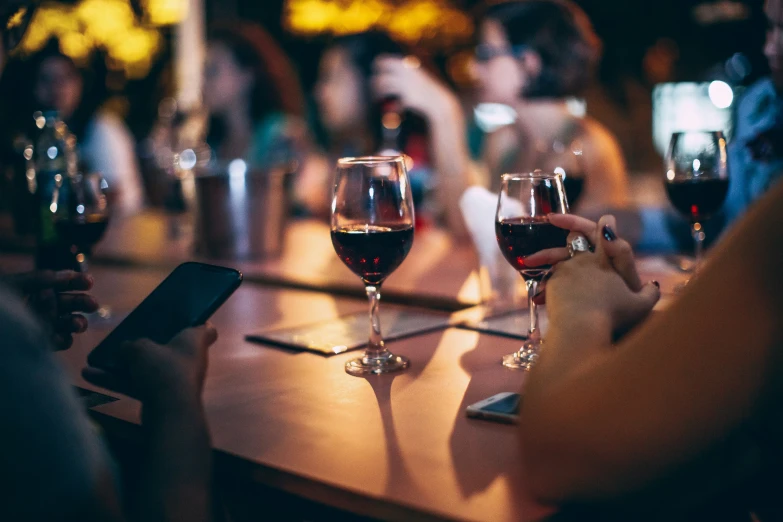 two glasses of wine on a table in front of people