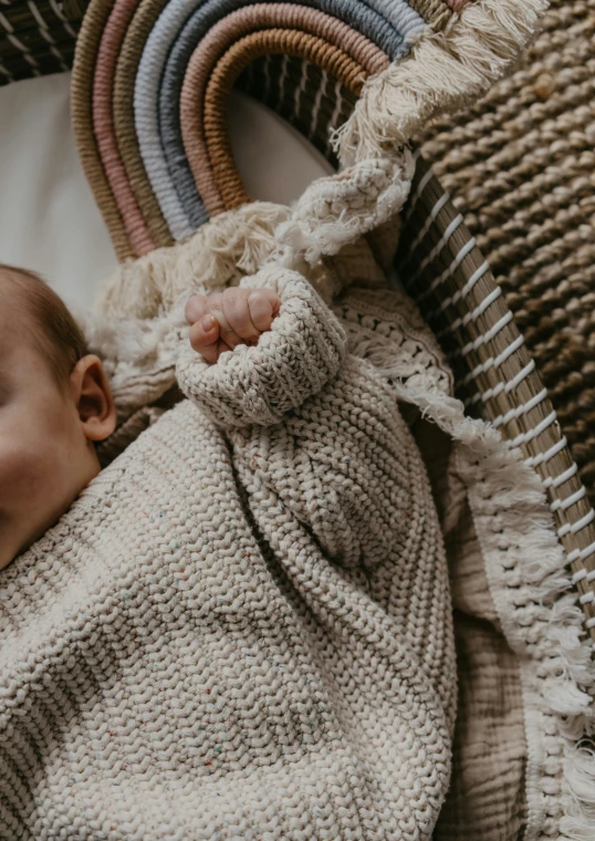 a baby is wrapped in a knitted blanket