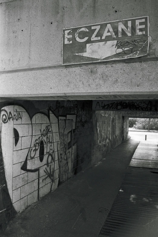 black and white pograph of graffiti on concrete overpass