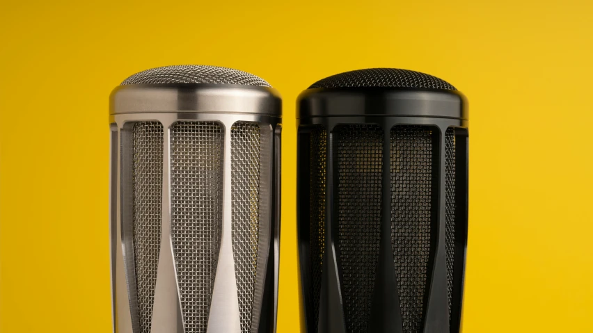 two metal objects are lined up against a yellow background