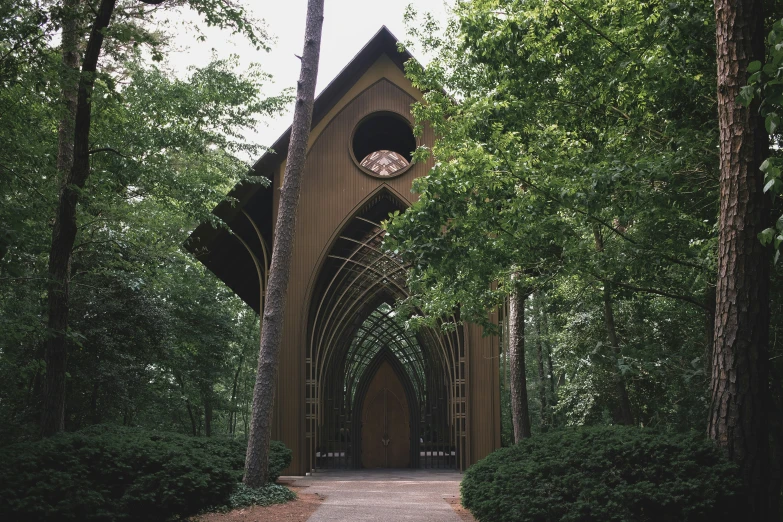 an archway in a wooden structure next to trees