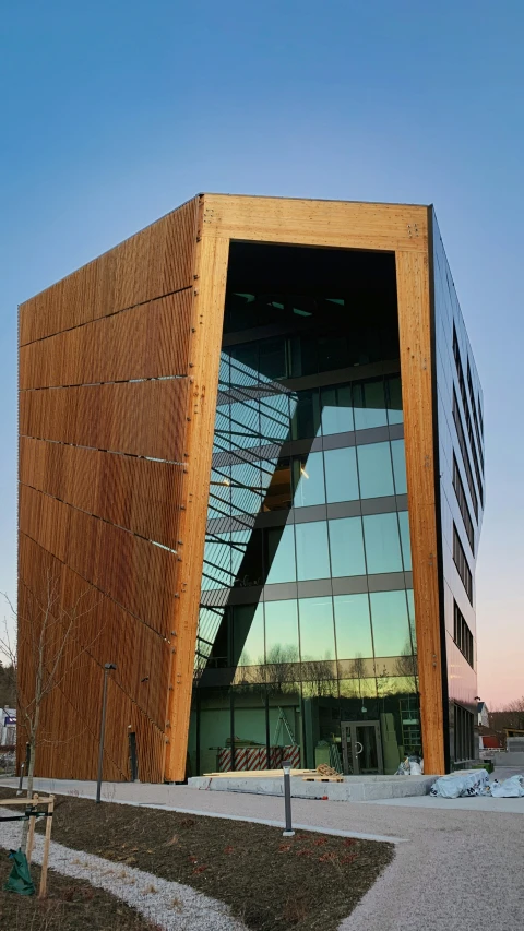 a large wood structure with glass windows stands beside a sidewalk