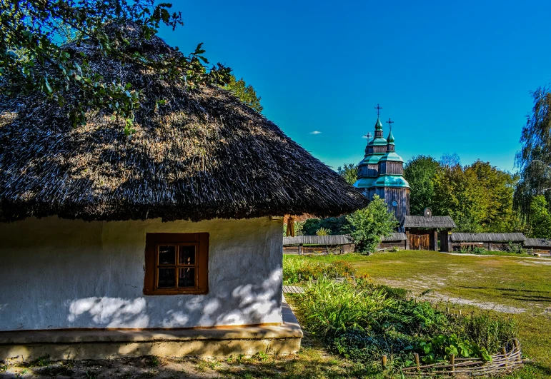 a little building with a thatch roof and two bell towers is shown