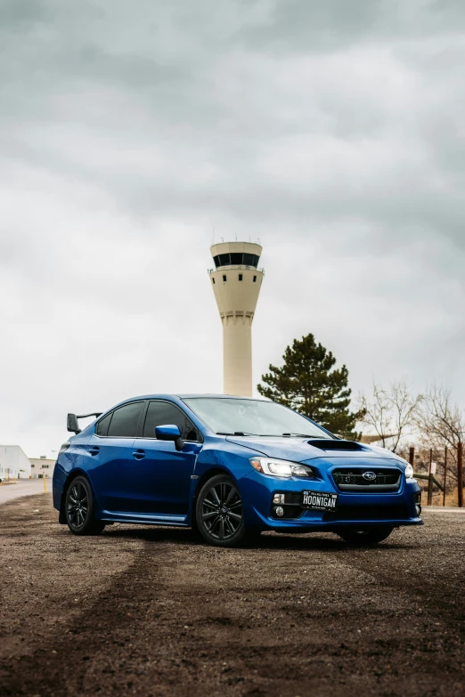 a blue subarunt sits in front of a control tower