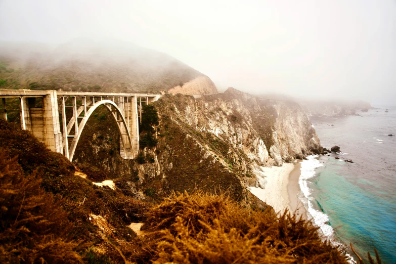 an old bridge is shown along the coast