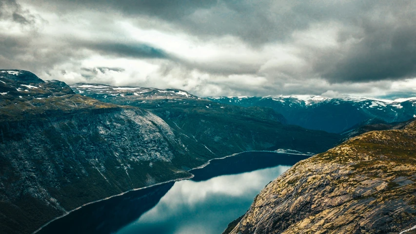 a bird perched on a hill above a body of water