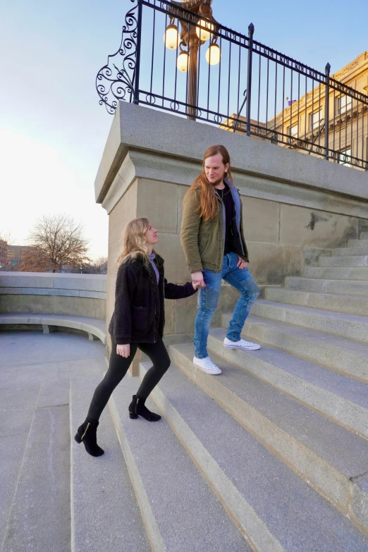 a man and woman are walking up the stairs