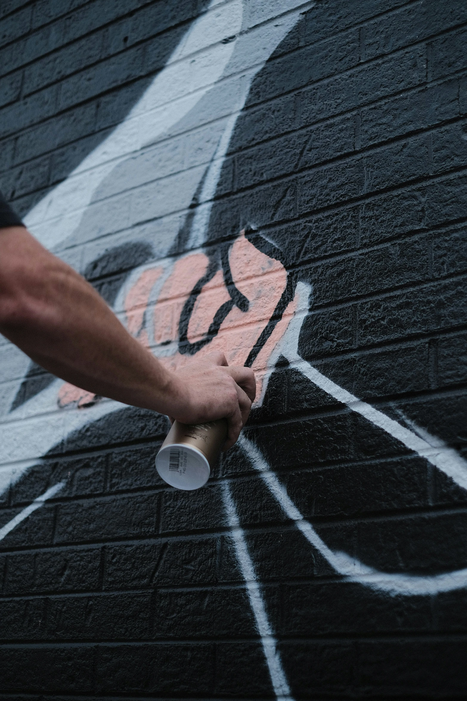 person holding onto an object in front of graffiti on the wall