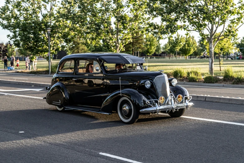 a vintage car is traveling down the road