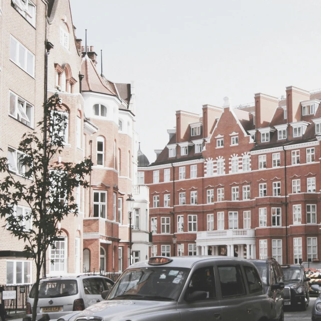 many cars parked in front of large brick buildings