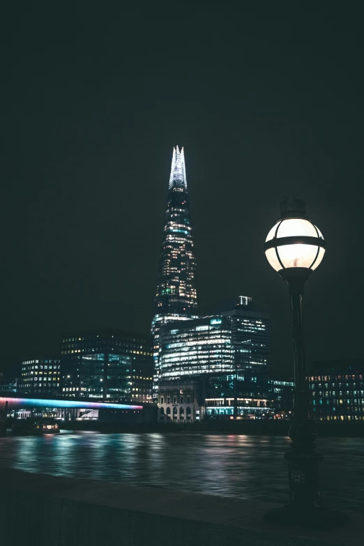 a large skyscr is lit at night by street lamps