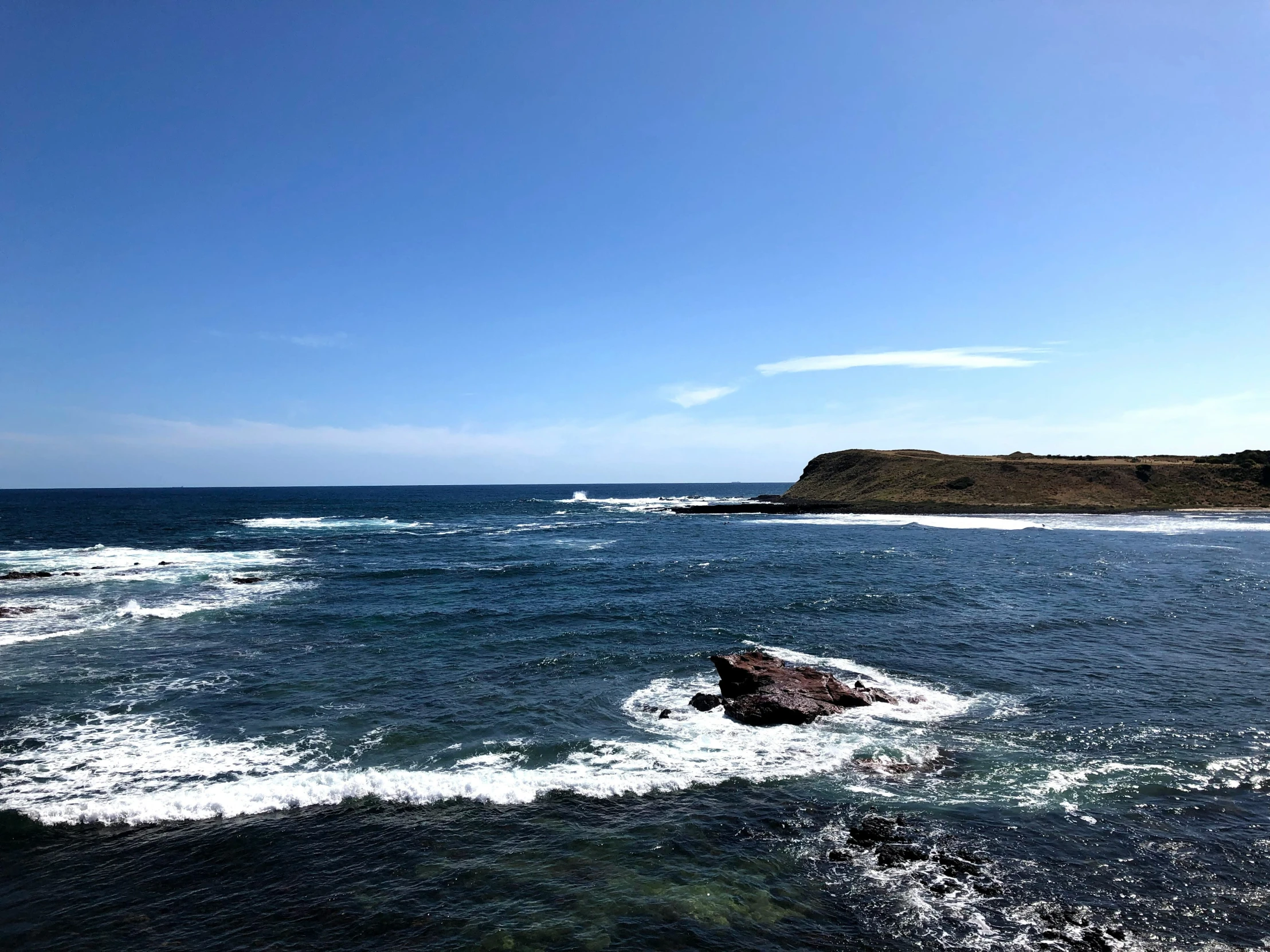 a body of water surrounded by rocks and a shore