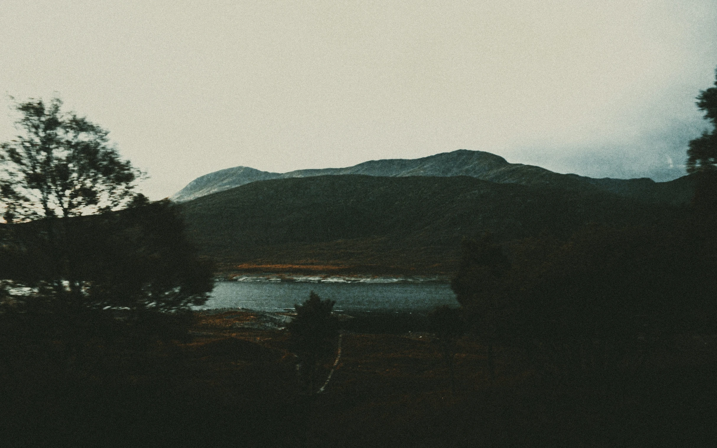 a lake is lit up and surrounded by hills