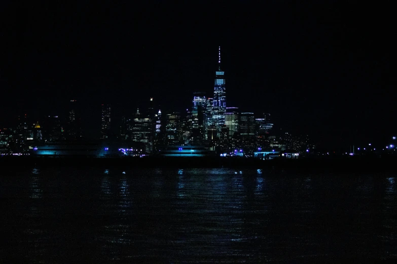 city lights reflected in water with skyline in background