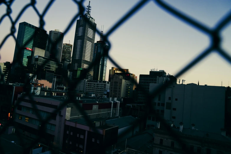 buildings are seen through a fence in a city