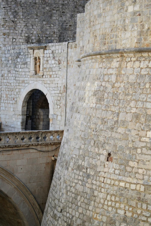 a man is walking over a bridge in an old stone wall