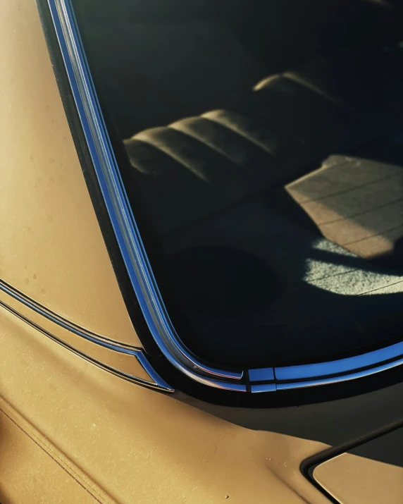 an old car with very clean windshield sits in the sun