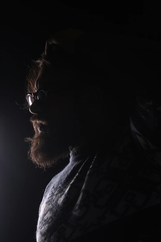 man looking at light at night in a darkened room