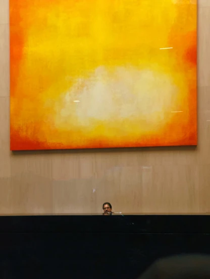 a man sitting at a desk in front of a painting