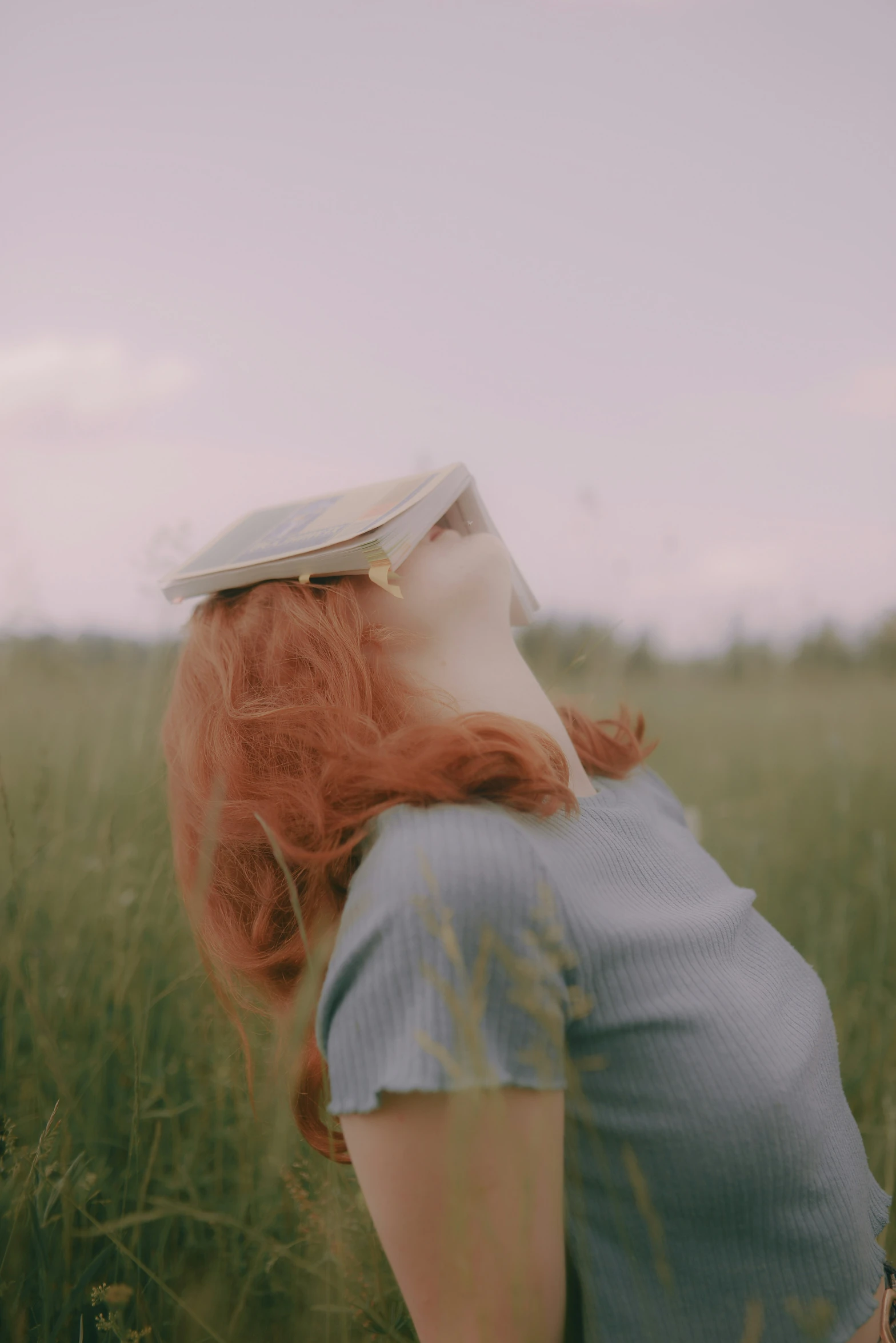 there is a red haired woman standing in a field