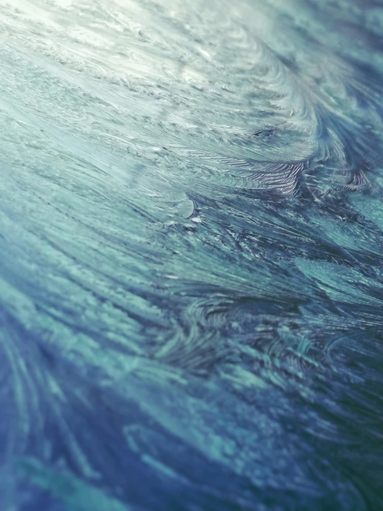 a blue green, swirly background with white waves and a small boat