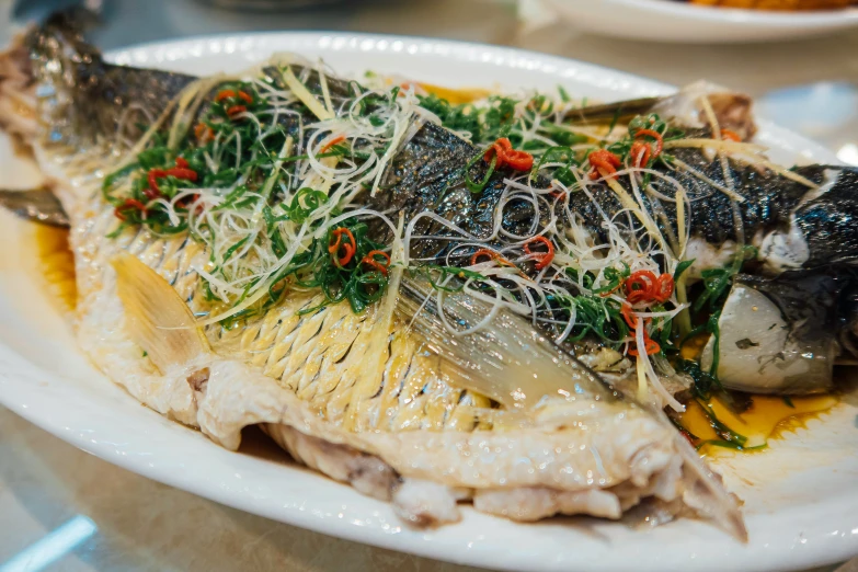 some fish are on a plate with green sprouts and other things