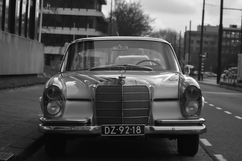 a vintage mercedes car parked on the side of the road