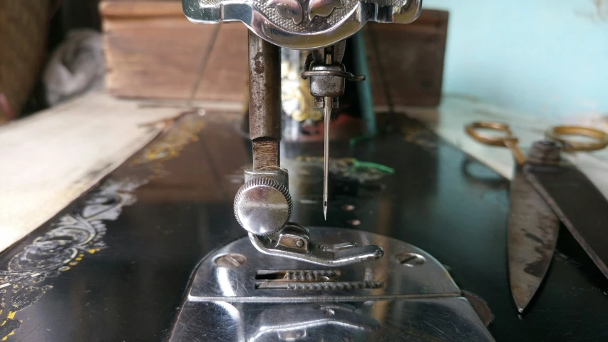 a metal sewing machine sitting on top of a wooden table