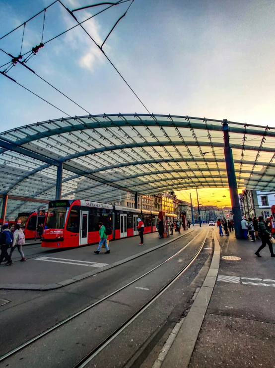 there are people walking in the street by some trains