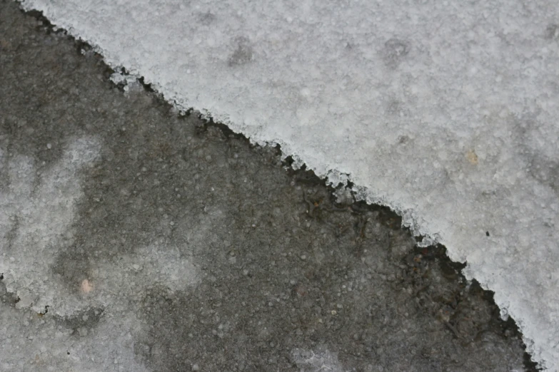 a close - up of the cement, some snow and rocks