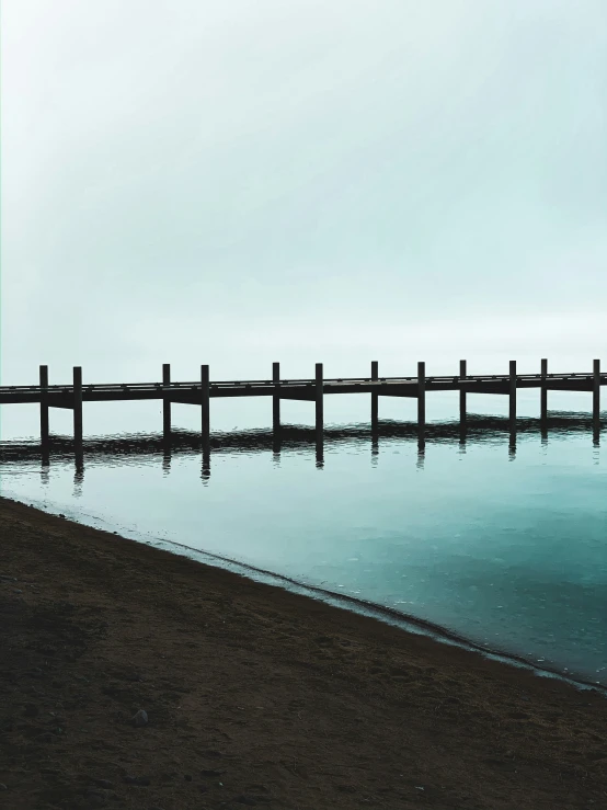 the water has a long pier stretching out into the distance