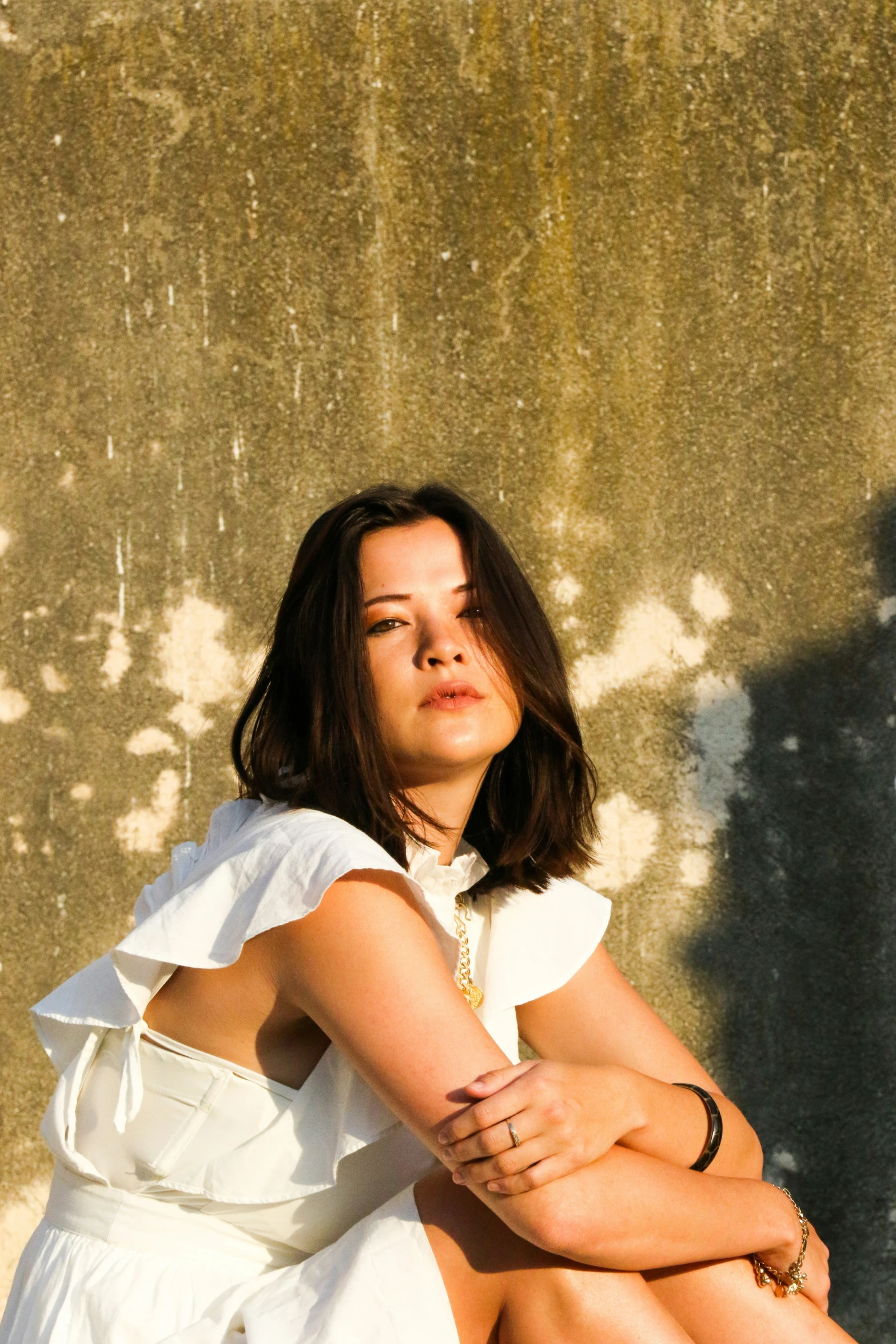 a woman is sitting on the floor wearing a dress