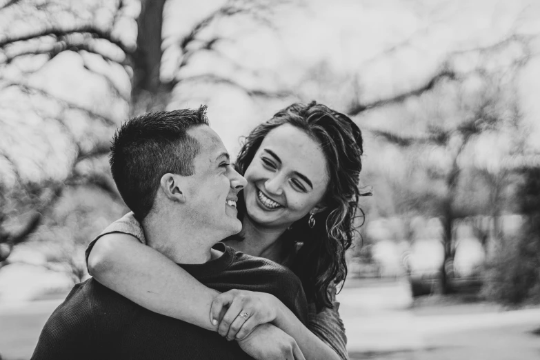 man and woman hug while smiling at each other