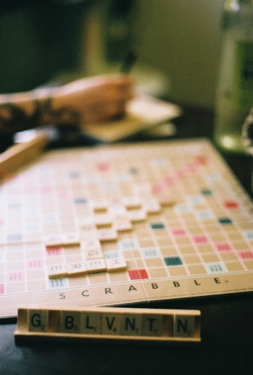 someone holding a knife on top of two scrabbles