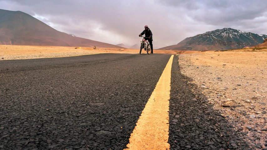 the man is riding his bike down a road