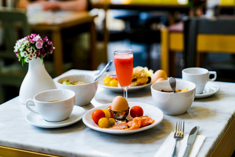 a table covered with breakfast foods with glasses of juice