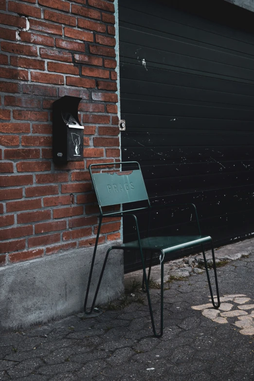 a chair standing against a brick wall near a door