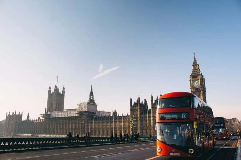 a red double decker bus drives along the road