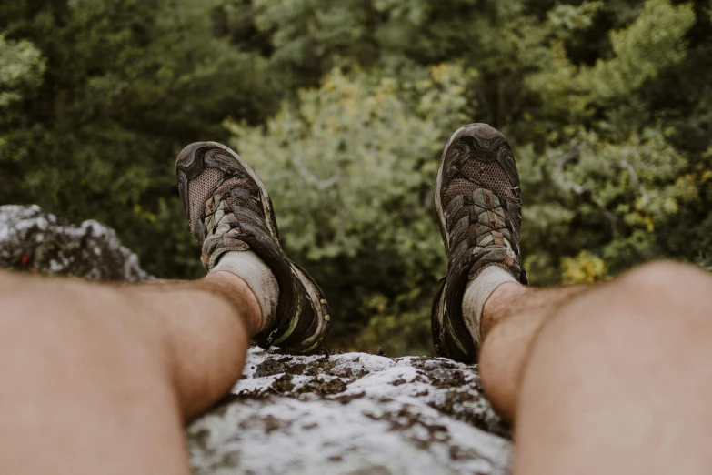 the bottom view of a person's feet and shoes standing on snow